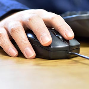 Hand holding a computer mouse.