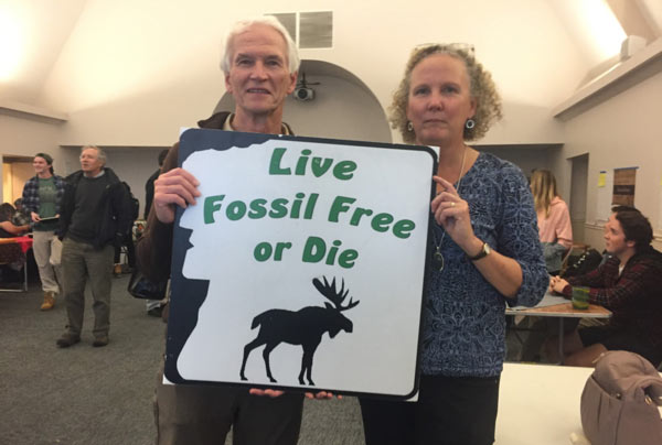 Couple holding sign Live Fossil Free or Die